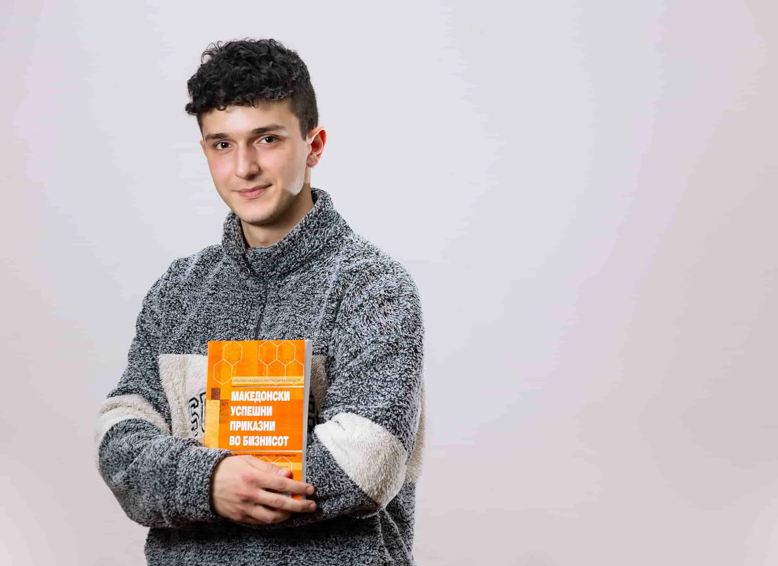 Young Man Holding a Textbook.